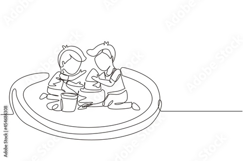 Single continuous line drawing two little boys build sandcastle together. Children sitting on sandbox and playing with sand castle. Brothers or friends having fun. One line draw graphic design vector