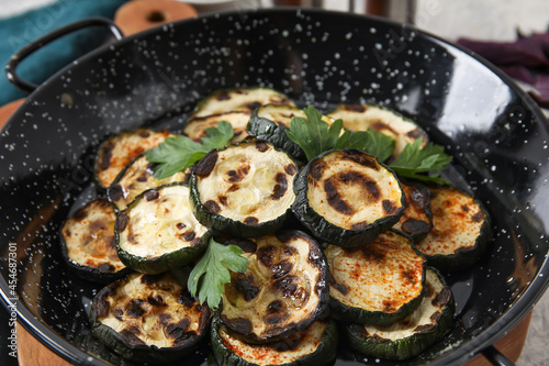 Frying pan with tasty grilled zucchini on table, closeup