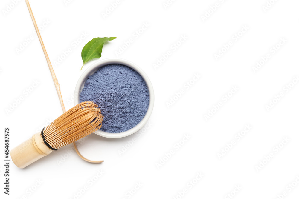 Bowl of powdered blue matcha tea, chasen and chashaku on white background Bowl of powdered blue matcha tea, chasen and chashaku on white background