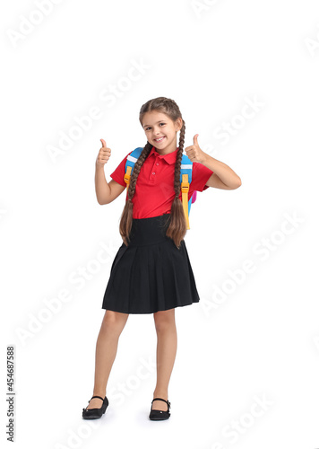Cute schoolgirl showing thumb-up on white background