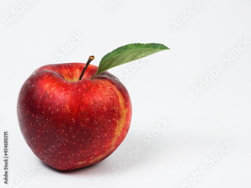 Red ripe apple with green leaf isolated on white background with free space for text 