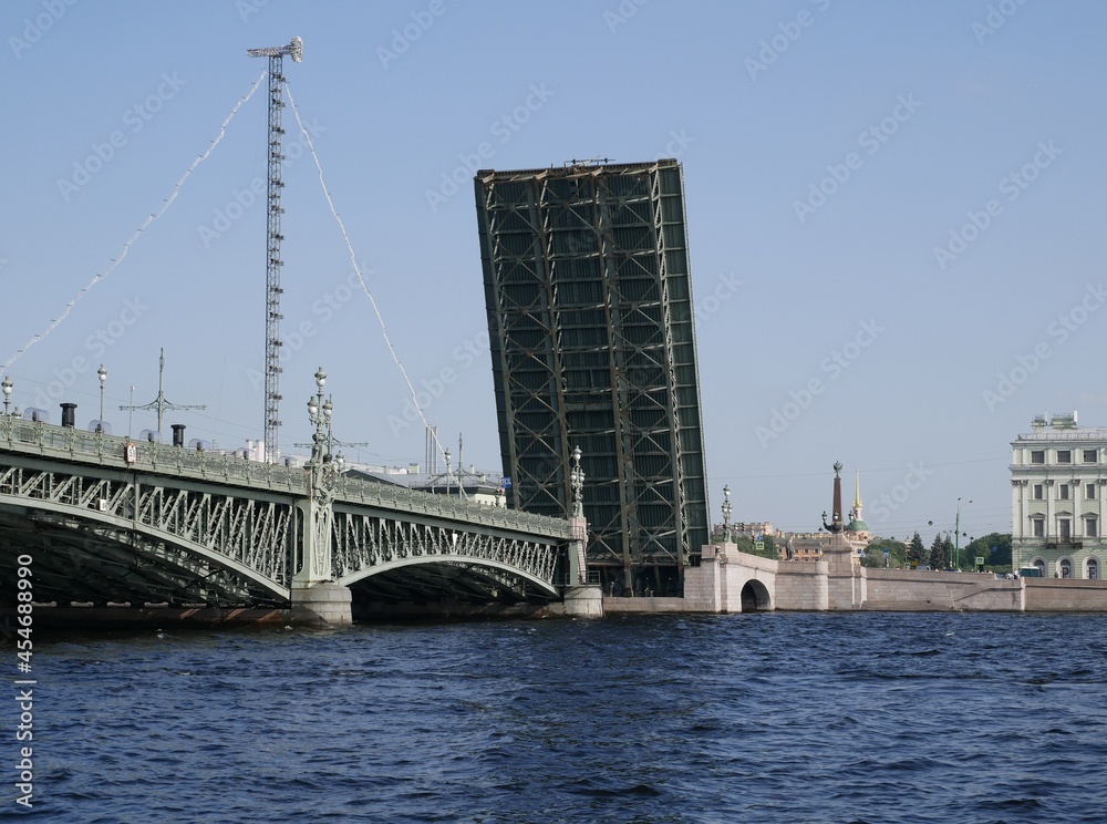 A Trinity Bridge drawbridge across the Neva River in St. Petersburg on a sunny summer day. A drawbridge connecting Vasilyevsky Island and the central part of the city. 