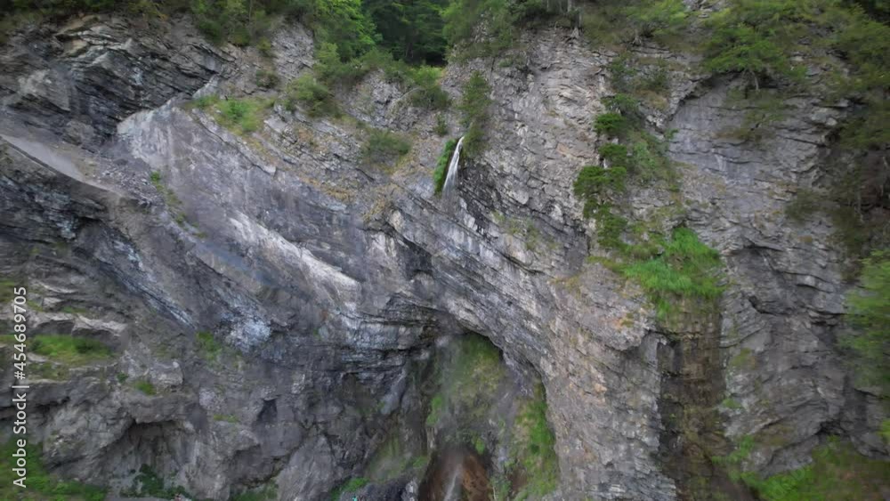 Revealing beautiful waterfall on rocky slope of mountain, inside green forest in Albania Revealing beautiful waterfall on rocky slope of mountain, inside green forest in Albania