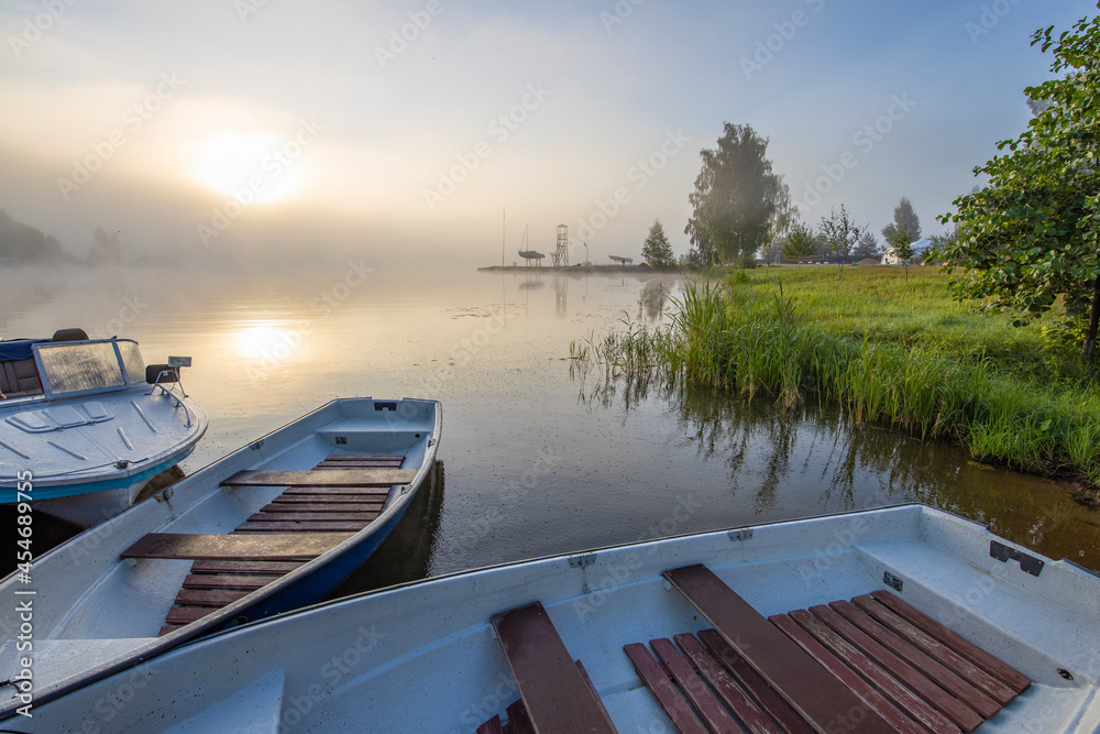Early morning. Fog on the river. Beautiful sunrise in the summer by the river. boats at the pier. Early morning. Fog on the river. Beautiful sunrise in the summer by the river. boats at the pier.