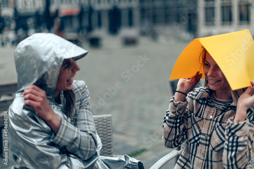 Canvas Print two young students and friends were caught off guard by the rain while sitting o