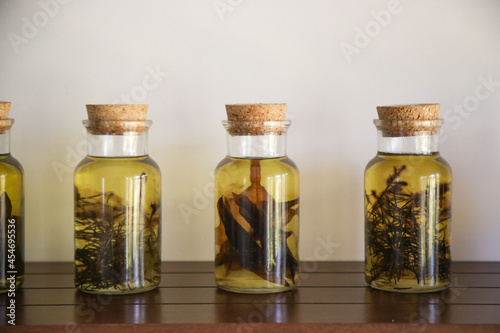 Herbs infused oil in glass jars. 
