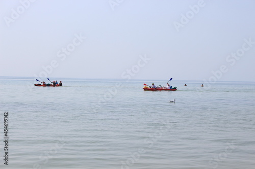 Tourists sail in kayaks on the sea around an island in the Black Sea