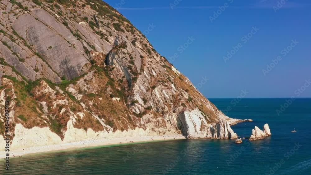 Aerial view of white rocky cliffs, down blue sea, deep white cliffs. White rocks, trees. Sea waves in blue seaside, white rocky bay, in a pristine ecosystem blue sky in a summer day in Conero, Italy Aerial view of white rocky cliffs, down blue sea, deep white cliffs. White rocks, trees. Sea waves in blue seaside, white rocky bay, in a pristine ecosystem blue sky in a summer day in Conero, Italy