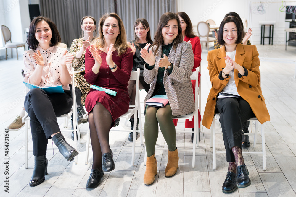 Fototapeta premium People listening to coach having speech at business training. A group of women attending seminar in conference hall. Life long learning , leadership development and management training concept