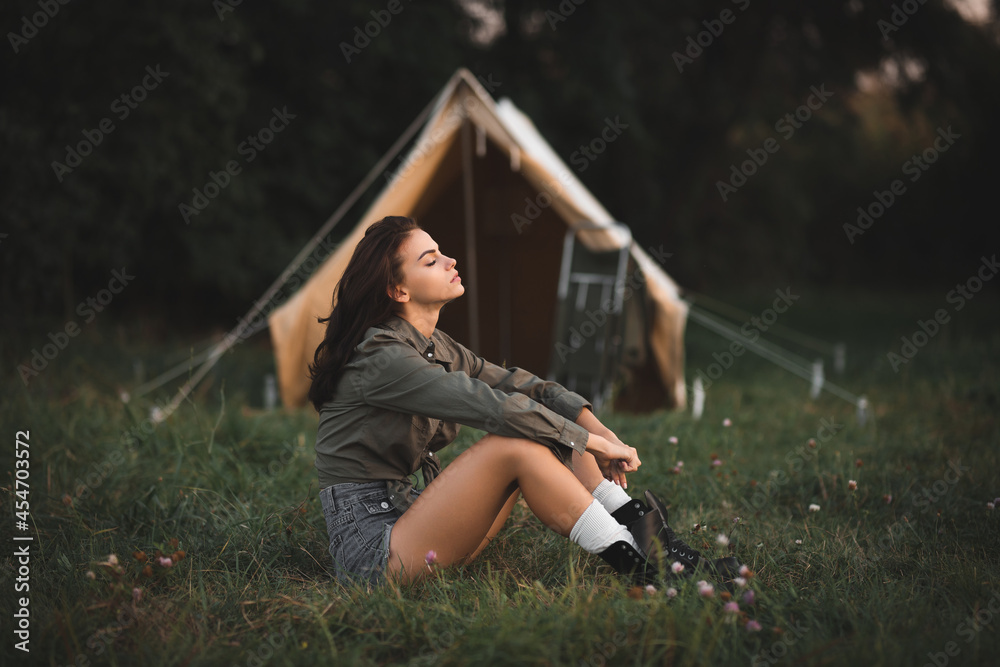 Camping with tents. Sexy young girl travels with a backpack. The girl on  the background of the tent. Stock Photo | Adobe Stock