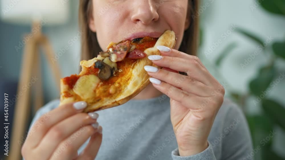 Woman eating pizza. Close-up. Concept of quick bites and unhealthy food Woman eating pizza. Close-up. Concept of quick bites and unhealthy food