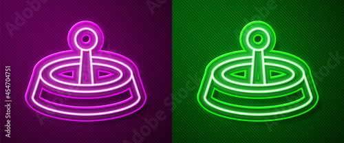 Glowing neon line Casino roulette wheel icon isolated on purple and green background. Vector
