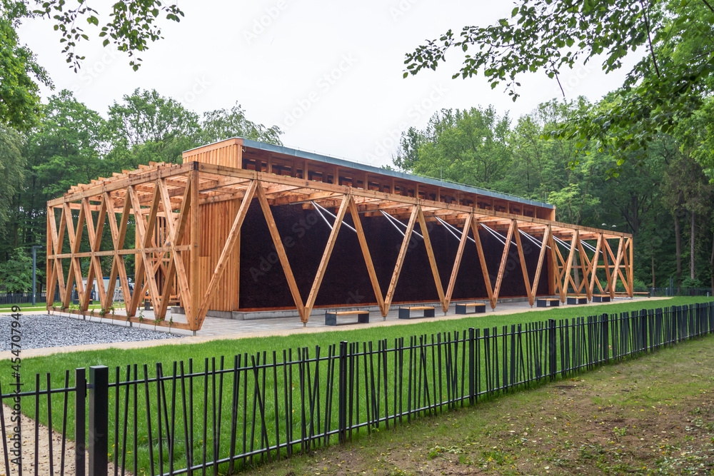 A graduation tower in a city park surrounded by greenery, a place for inhalation and recreation, a structure made of wood and blackthorn