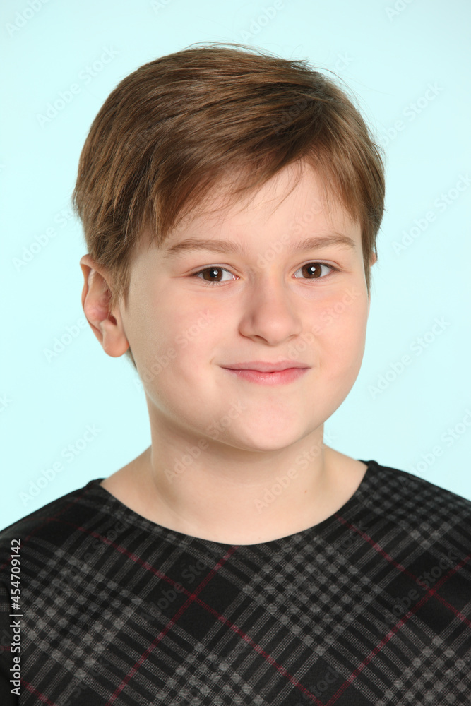 A cheerful and mischievous teenage boy smiles slightly in a close-up portrait, looking eye to eye. A cheerful and mischievous teenage boy smiles slightly in a close-up portrait, looking eye to eye.