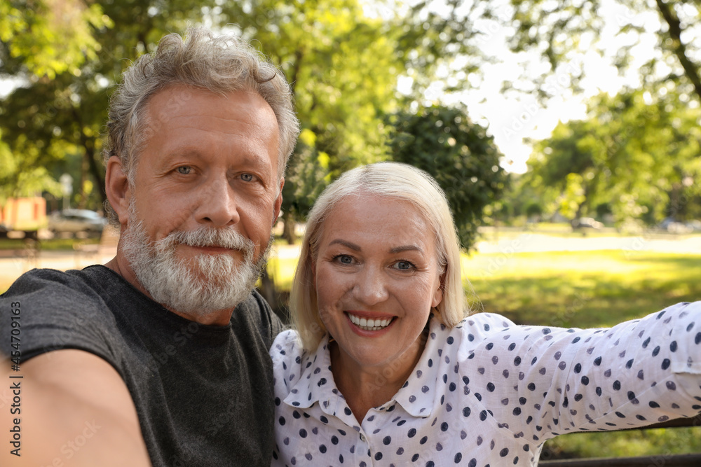 Lovely mature couple taking selfie in park Lovely mature couple taking selfie in park