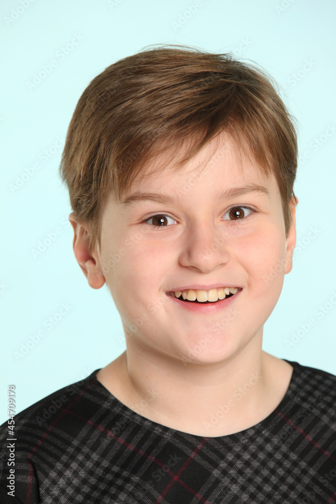Cheerful and mischievous teenage boy smiling in a close-up portrait looking eye to eye. Cheerful and mischievous teenage boy smiling in a close-up portrait looking eye to eye.