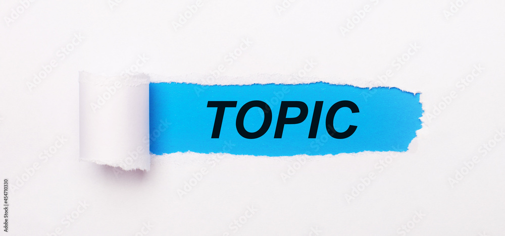 On a bright blue background, white paper with a torn stripe and the text TOPIC On a bright blue background, white paper with a torn stripe and the text TOPIC