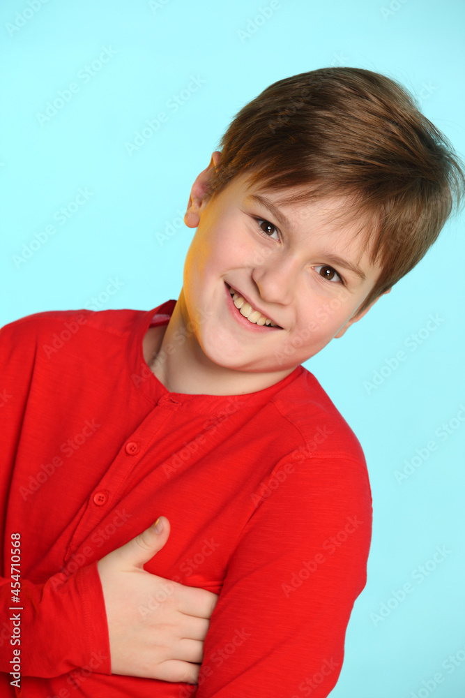 Close-up portrait: trendy, cheerful teenage boy in a red sweater. He smiles broadly and looks eye to eye. Close-up portrait: trendy, cheerful teenage boy in a red sweater. He smiles broadly and looks eye to eye.