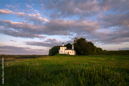 Saint Nicholas Church in Gorodishche  (Nikolskaya church) on Truvorov Gorodishche on a sunny summer evening with clouds. Stary Izborsk, Pskov Oblast, Russia photo
