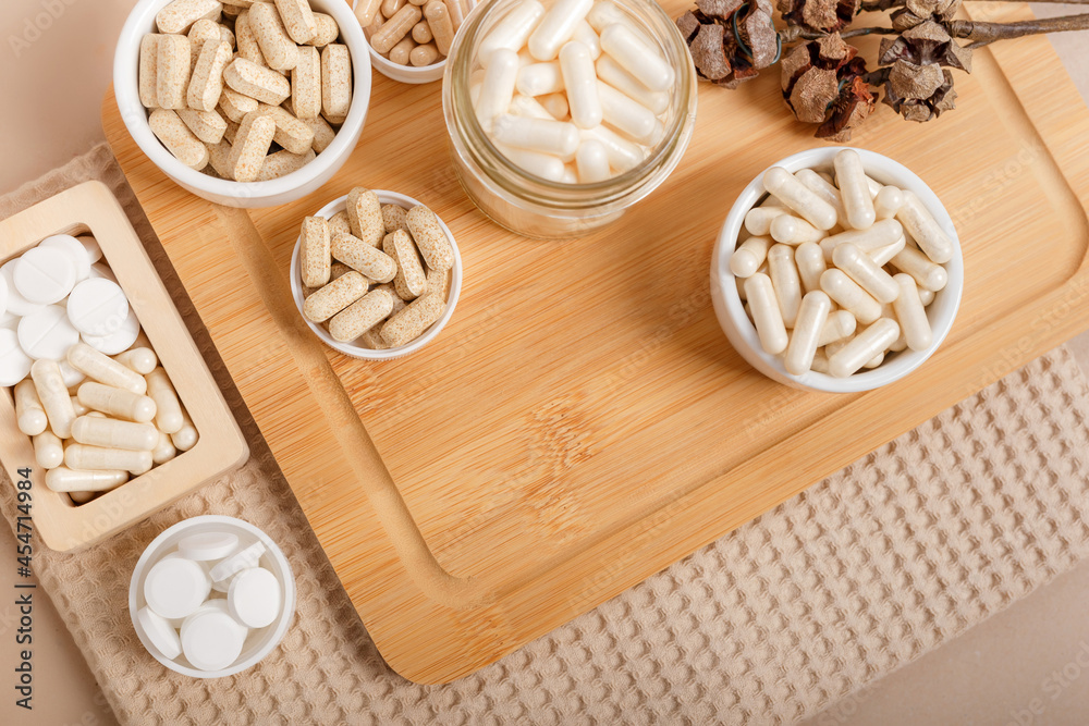 Nutritional supplement and vitamins to support human health and immune system on brown background. There are such organic vitamins as omega 3, chelated magnesium, zinc, vitamin C, multivitamin complex Nutritional supplement and vitamins to support human health and immune system on brown background. There are such organic vitamins as omega 3, chelated magnesium, zinc, vitamin C, multivitamin complex