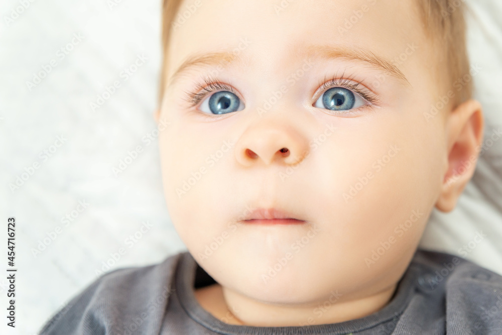 Extreme close-up portrait of a ten-month-old baby boy. Blue eyes red haired little child.