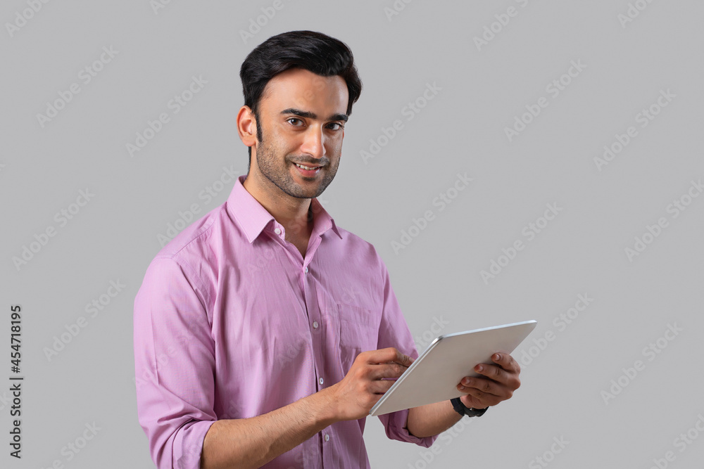 An employee in formal clothing holding a digital tablet,looking at the camera. An employee in formal clothing holding a digital tablet,looking at the camera.