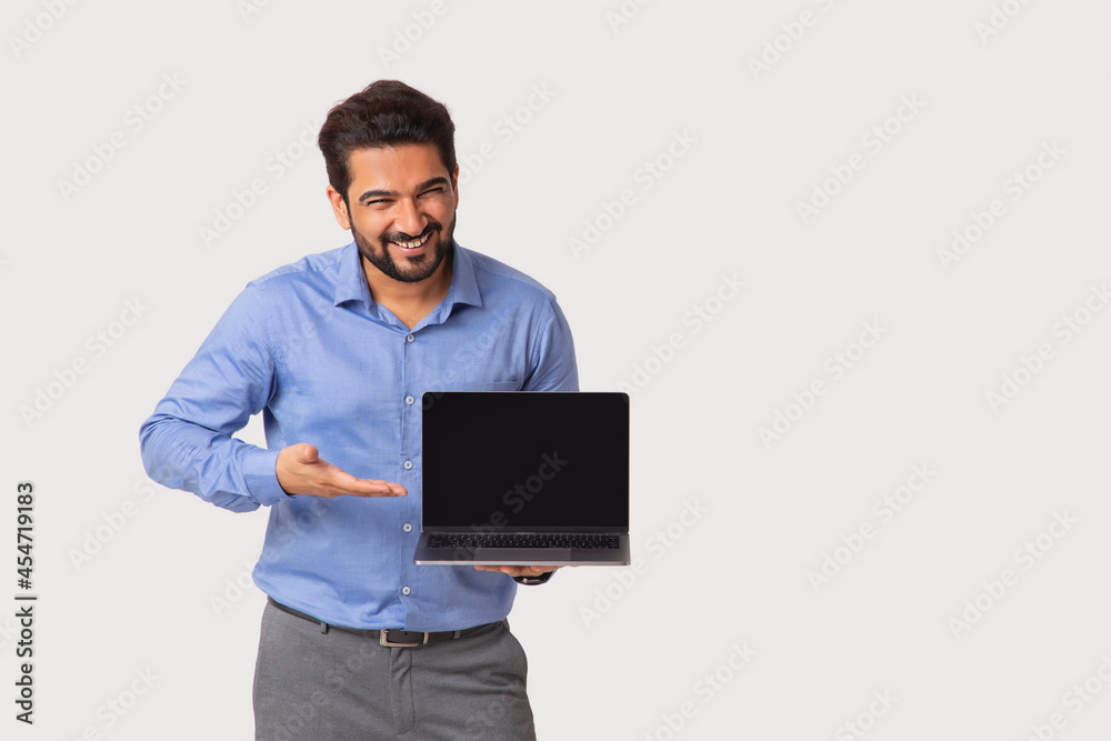 Portrait of a man in formal clothing showing the laptop in his hand.