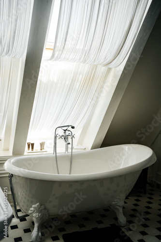 bathroom with window. interior in vintage style. bath on the legs.