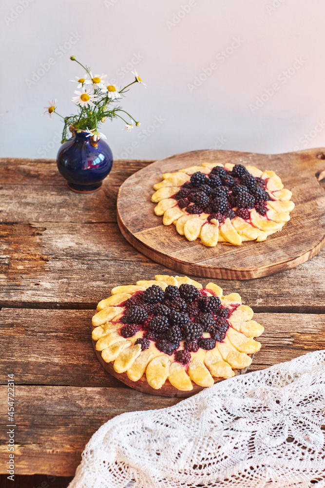 blackberry flower pie on a wooden table. Flowers, coffee, shortcrust pastry, ricotta, ice cream, chamomile, side view. blackberry flower pie on a wooden table. Flowers, coffee, shortcrust pastry, ricotta, ice cream, chamomile, side view.