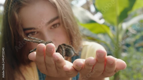 nature girl holding tarantula spider at zoo enjoying excursion to wildlife sanctuary student having fun learning about arachnids 4k photo