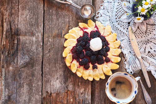 blackberry flower pie on a wooden table. Flowers, coffee, shortcrust pastry, ricotta, ice cream, chamomile, top view.