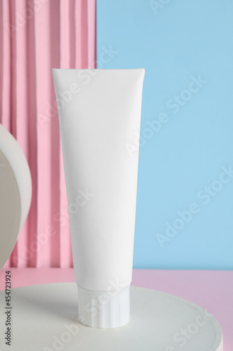 Blank tube of toothpaste on color background