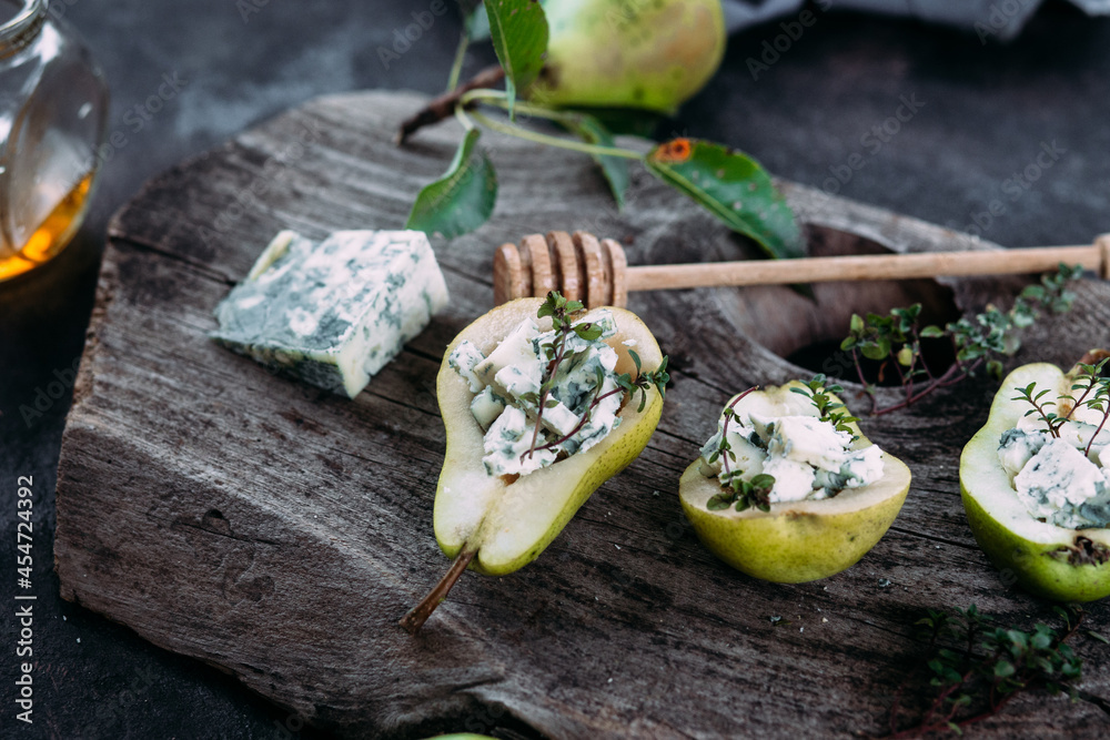 Pear with dor blue cheese and honey on a wooden background