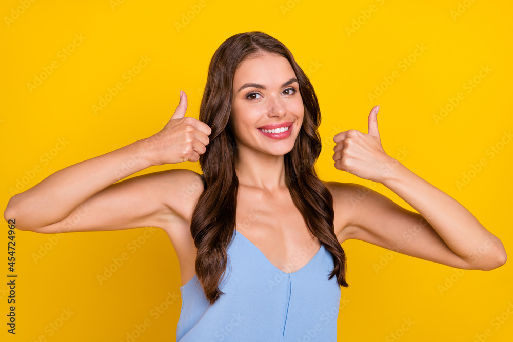 Photo of young woman happy positive smile show thumbs-up feedback advert recommend isolated over yellow color background Photo of young woman happy positive smile show thumbs-up feedback advert recommend isolated over yellow color background