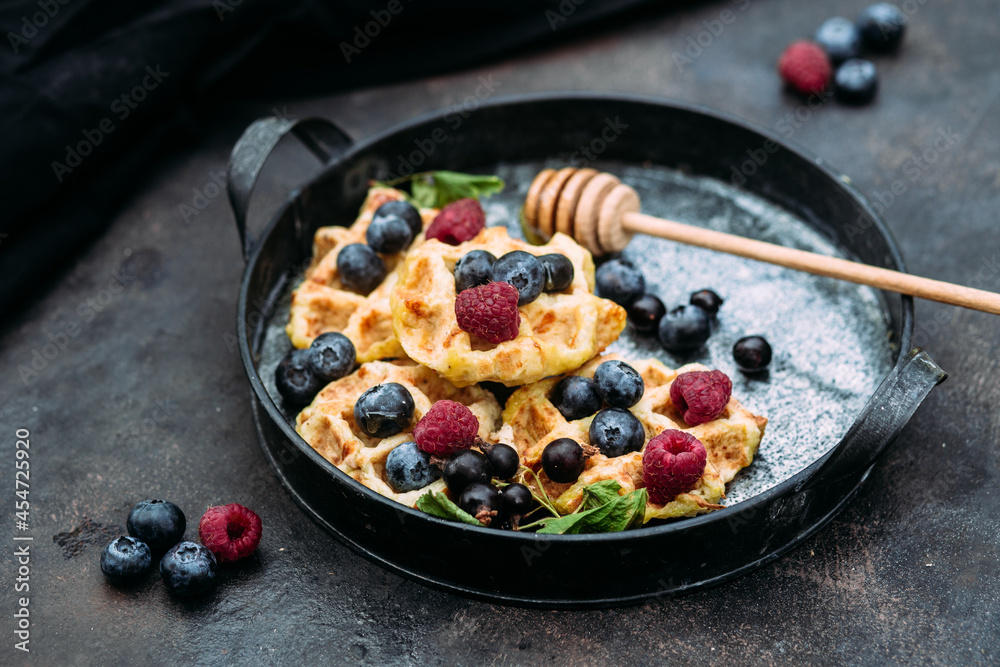 Belgian sweet waffles with blueberries, raspberries and honey