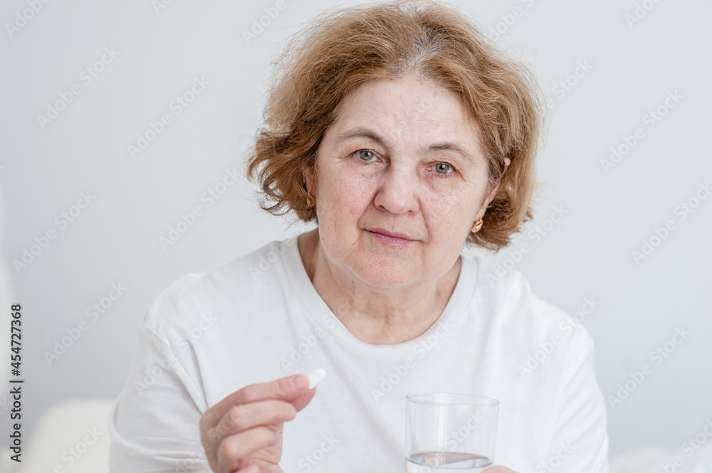 Sick senior woman holdis pills and glass of water Sick senior woman holdis pills and glass of water