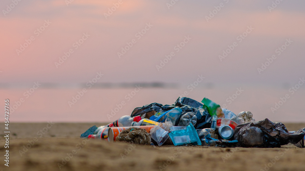 Big pile of garbage lying on a beach of a sea. Environmental pollution. Ecological problem. Empty space for text