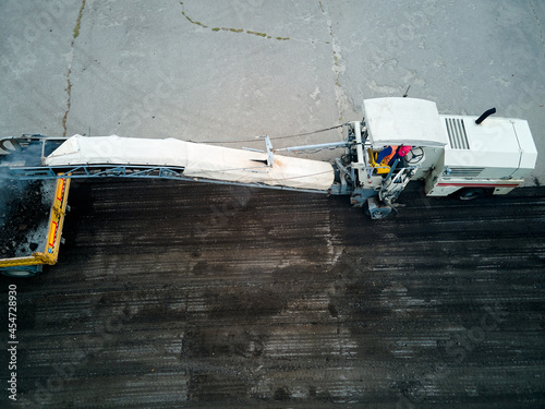 Top view, The road milling machine removes the top layer of asphalt from the road section and loads it onto the tipper