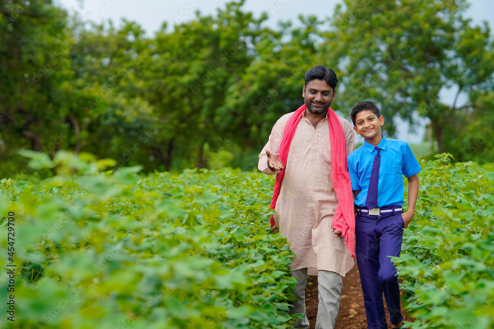 Indian farmer with his son at agriculture field Indian farmer with his son at agriculture field