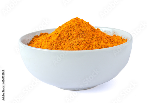 Turmeric roots and turmeric powder in white bowl isolated on white background