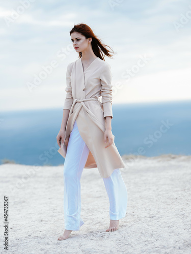 beautiful woman in coat sand summer elegant style