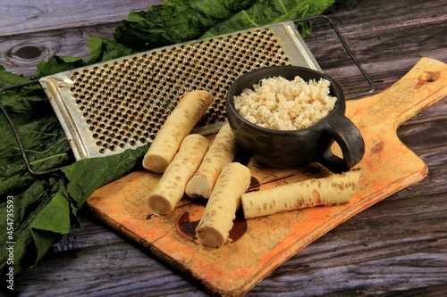 Fresh grated Horseradish roots on wooden table. The root of horseradish