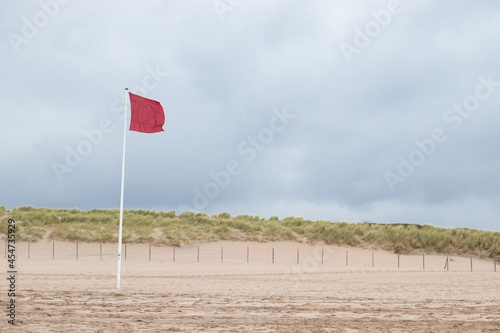 A red flag along the Dutch coast indicating it's forbidden to swim in the ocean (Kijkduin, The Hague, The Netherlands)