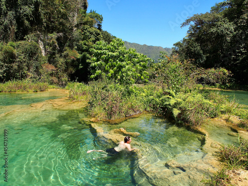 Semuc Champey, Guatemala - 17.03.2019: Man swimming in natural pools at Semuc Champey photo