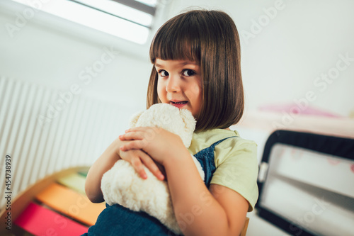 Little cute child girl huggs a teddy bear photo