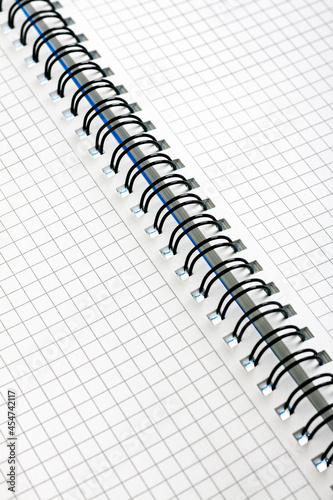 Open notebook with checkered sheets with a spring