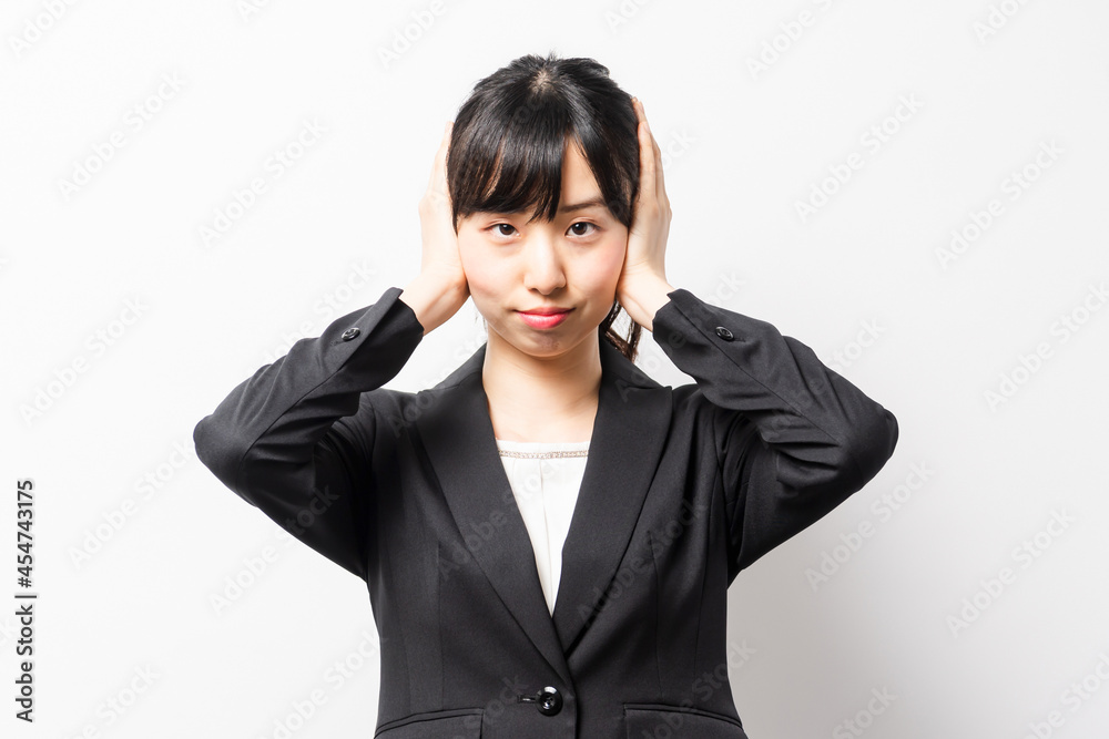 両手で耳を塞ぐ若いビジネスウーマン 両手で耳を塞ぐ若いビジネスウーマン