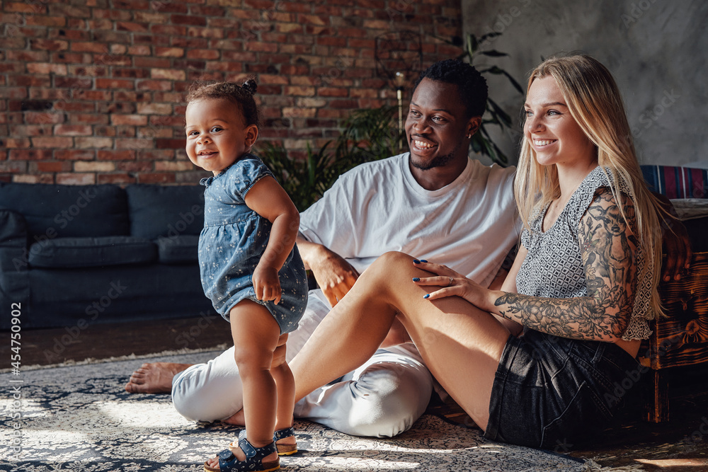 Mother and father playing with their daughter at home