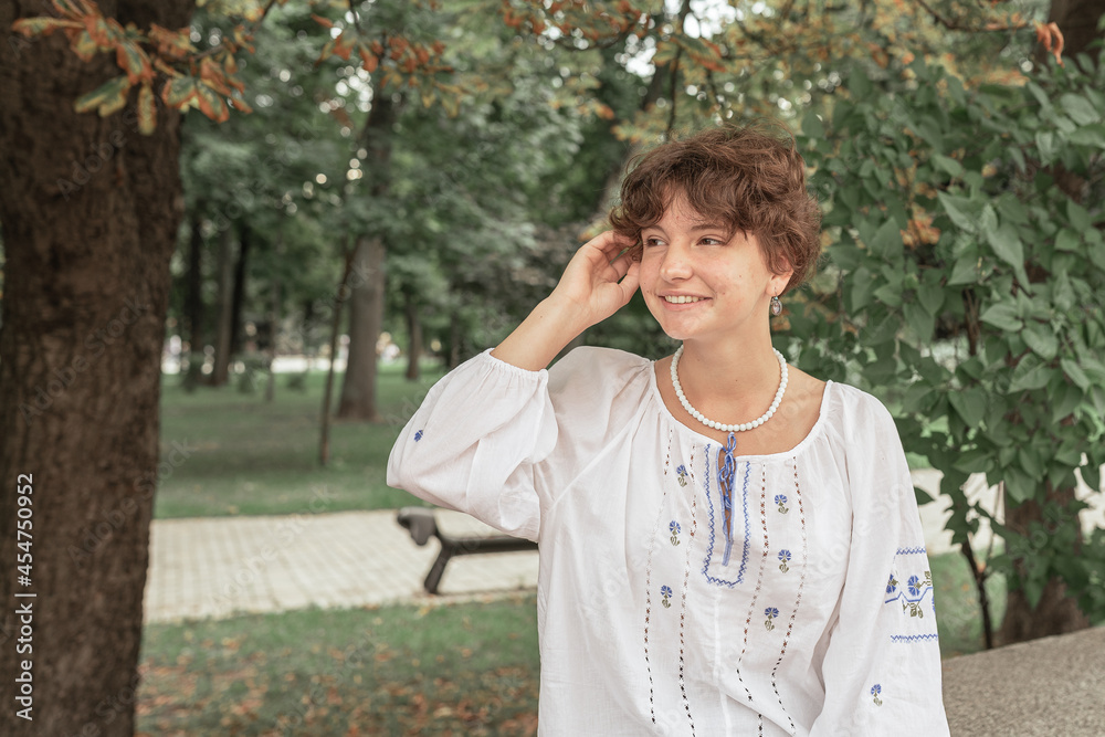 teen girl in national embroidered shirt in the park teen girl in national embroidered shirt in the park