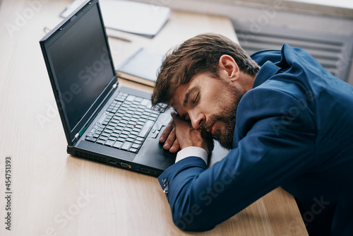 business man sleeping in front of laptop at his desk office